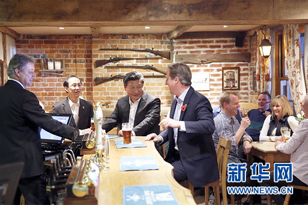這是會晤結束后，習近平在卡梅倫陪同下乘車前往當地小鎮體驗酒吧文化。新華社記者 鞠鵬 攝